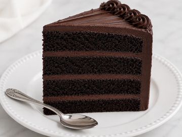 A slice of rich chocolate cake with a spoon.