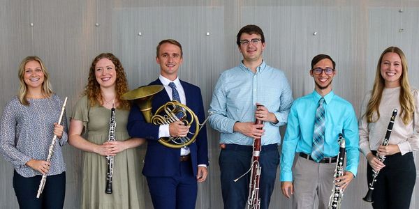 Group of six musicians holding wind instruments.
