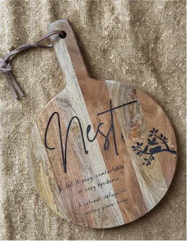 Wooden board with the word 'Nest' and a cozy home message.