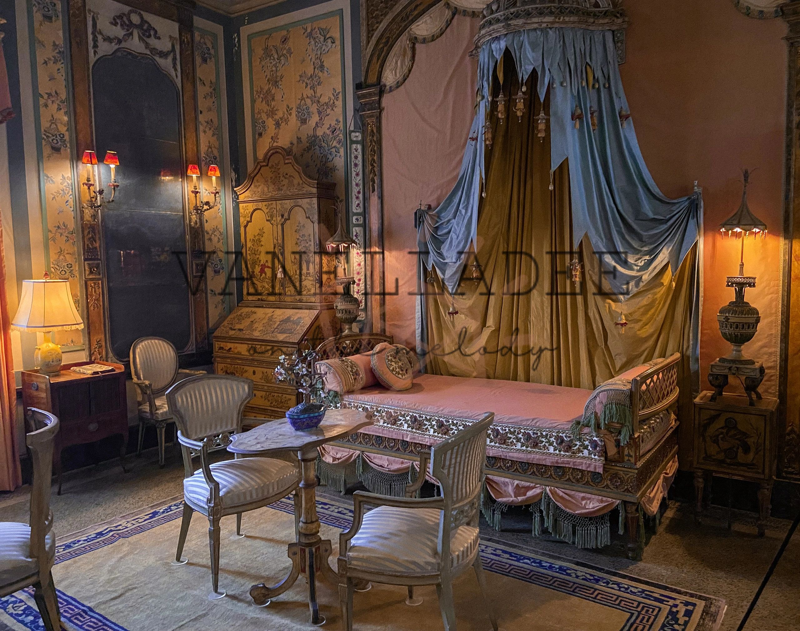 Vintage room with ornate furniture and draped canopy bed.