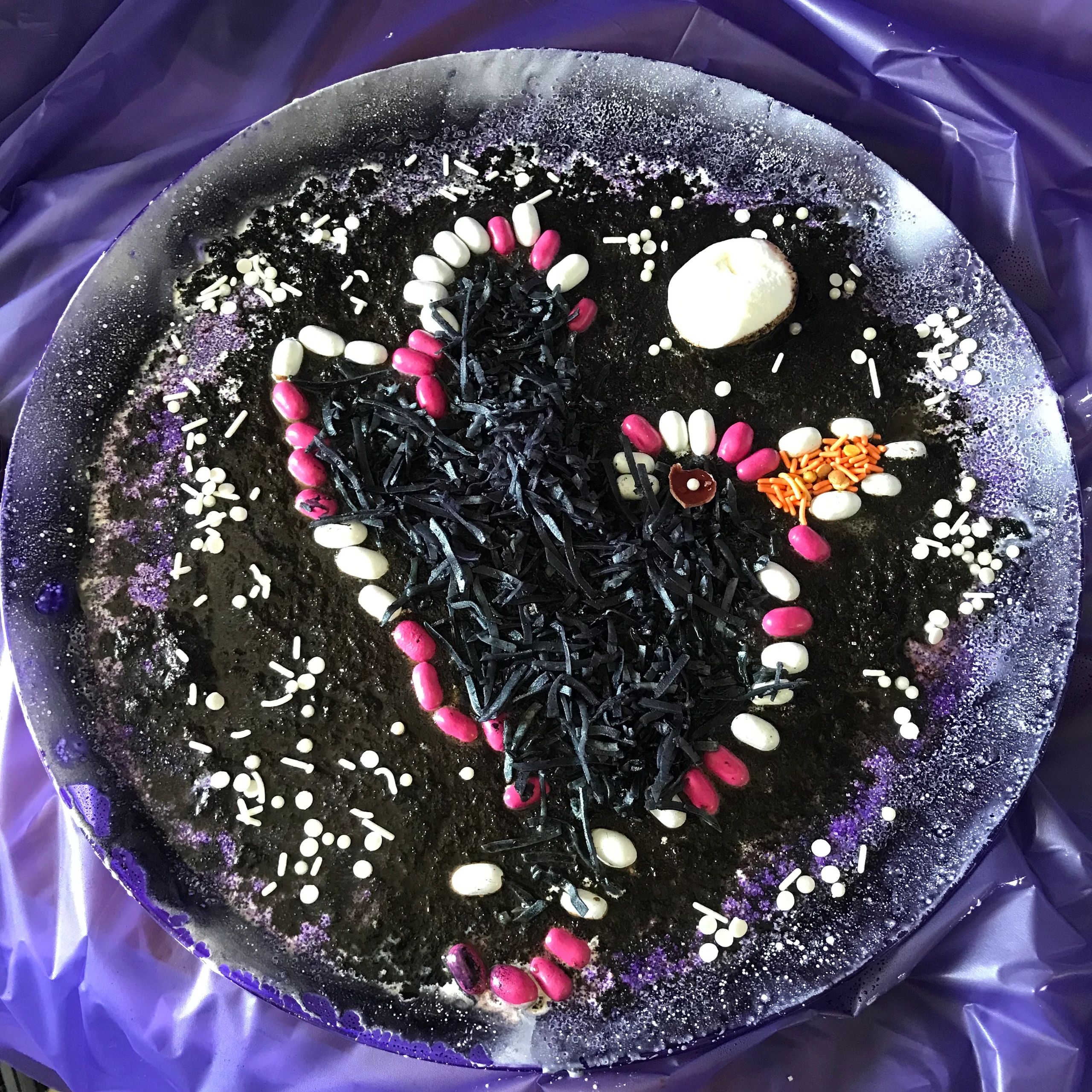 Halloween-themed cake with spooky face and candy decorations.