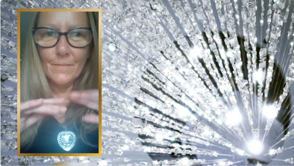 Woman with glowing heart-shaped pendant and crystal lights background.