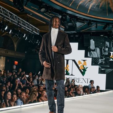 Model walking on runway in a fashion show.