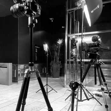 Black and white photo of a camera and lighting setup on tripods.