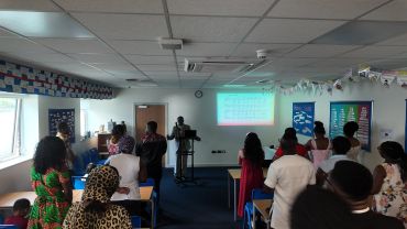 People attending a classroom lecture with a projected musical score on the wall.