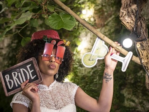 Bride holding props wearing funny glasses