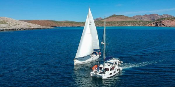 Dos velero navegando en aguas azules.