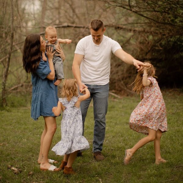 Family dancing outside in nature.
