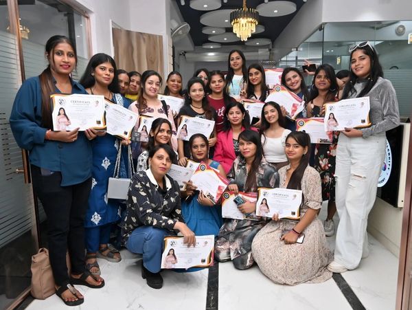 Group of women proudly holding their certificates indoors.