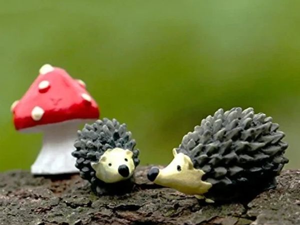 Two hedgehog figurines with a red mushroom.