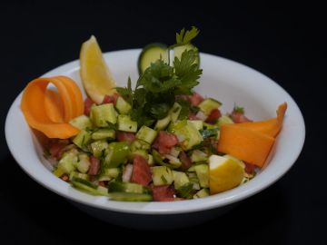 Renkli sebze salatası, otlarla süslenmiş.