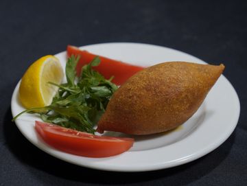 İçli köfte, domates, limon ve maydanozlu tabak.