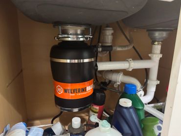 Kitchen sink disposal unit installed under sink.