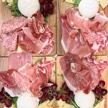 Examples of our aperitivo boards with cured meats, cheeses and grapes.