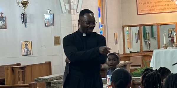 Father Chidi asks questions to the participants at the Large Group Reflections VBS - Day 1
