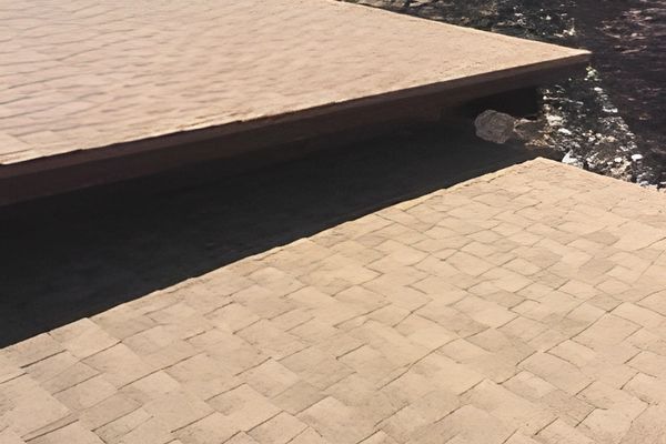 Asphalt shingles are installed on a low-pitch roof.