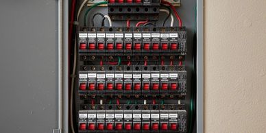 Open electrical panel with organized circuit breakers and wiring.
