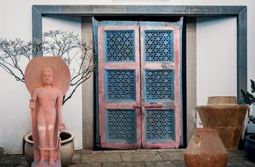 Antique Red stone buddha, the iron pots or the jaali door