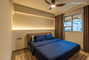 Modern bedroom with blue bedding and warm ambient lighting.