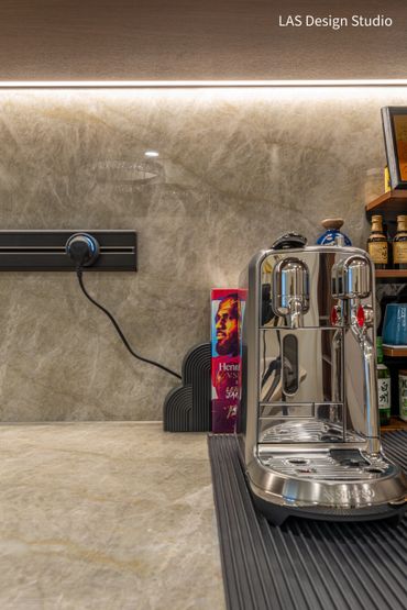 Sleek espresso machine on modern kitchen counter with backlit backsplash.