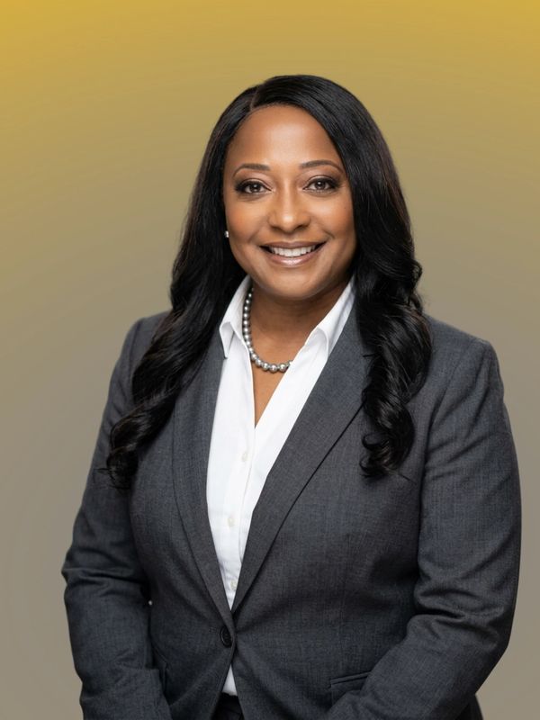 Professional woman in gray suit smiling confidently.