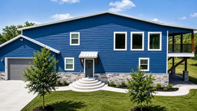 Blue modern two story house with balcony, garage, carport. Burnet tx