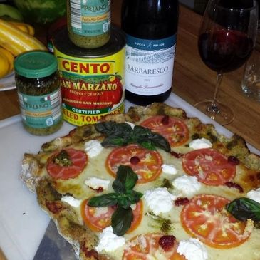 A pizza is shown for the cooking competitions with a can of tomatoes and a bottle of wine.