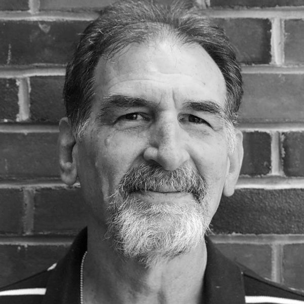 A black and white photo in a circular shape of Mr. Steve Ruskin.