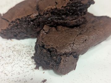 Close-up of rich, fudgy chocolate brownies with a cracked top.