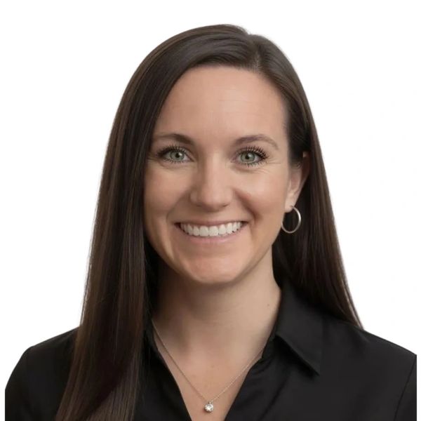 Smiling woman with long brown hair, wearing a black shirt and silver jewelry.
