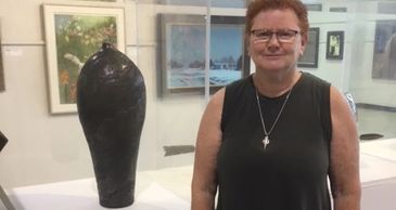 Lyn Reed standing next to work at the Minnesota State Fair.