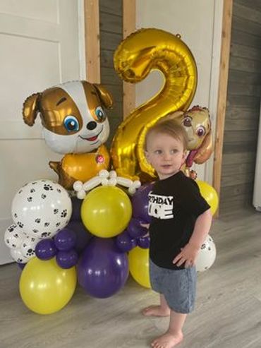 Paw Patrol balloon arrangement with Rubble, paw print balloons, and balloon dog bones.