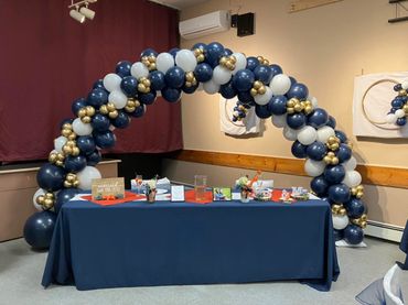 Large balloon arch in navy, and white balloons, with small gold cluster balloon detailing. 
