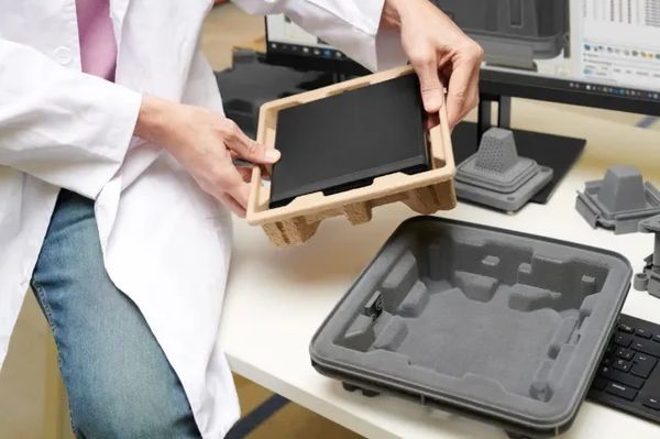 Pessoa segurando uma embalagem protetora para um tablet.
