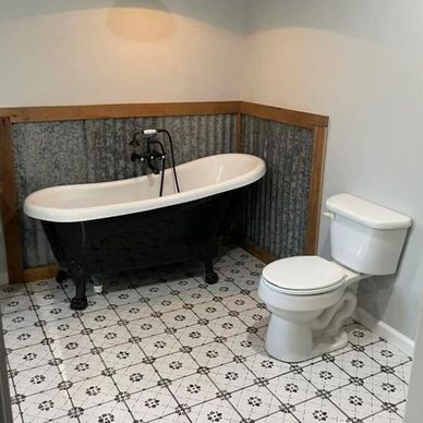 Vintage bathroom remodeled with a new toilet and a claw foot bathtub.