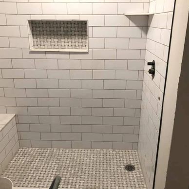 Tile shower with inset storage shelf and seat.