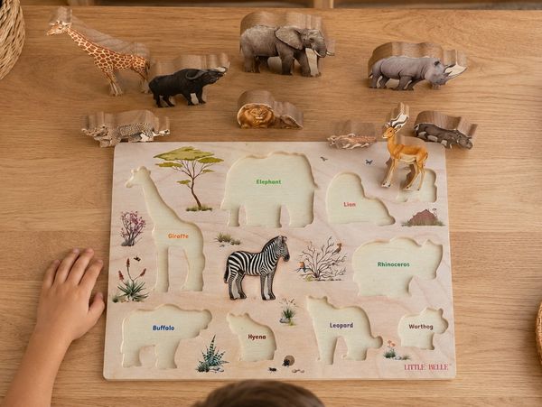 Wooden animal puzzle with African wildlife pieces beside it.