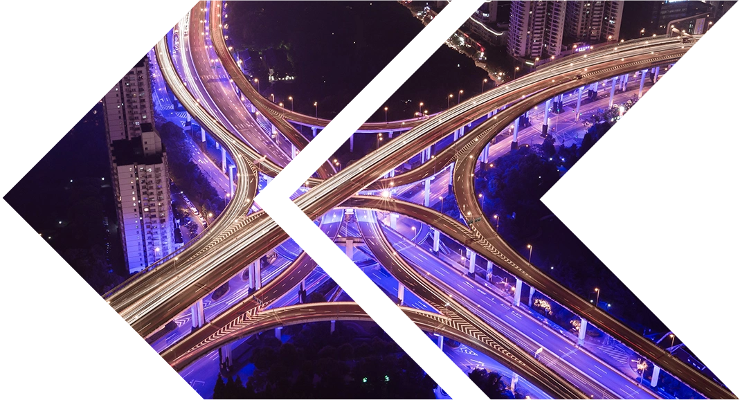 Double chevron Shift Left logo filled with arial view of a road junction at night