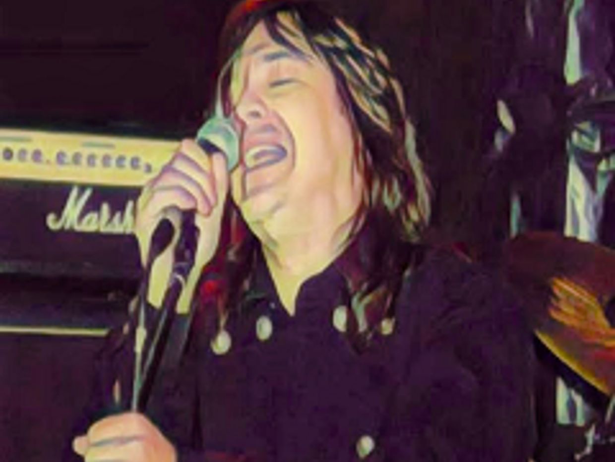 Singer passionately performing on stage with microphone.