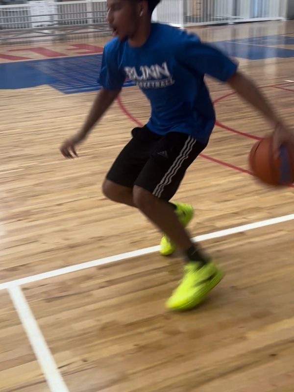 Young man dribbling a basketball indoors.