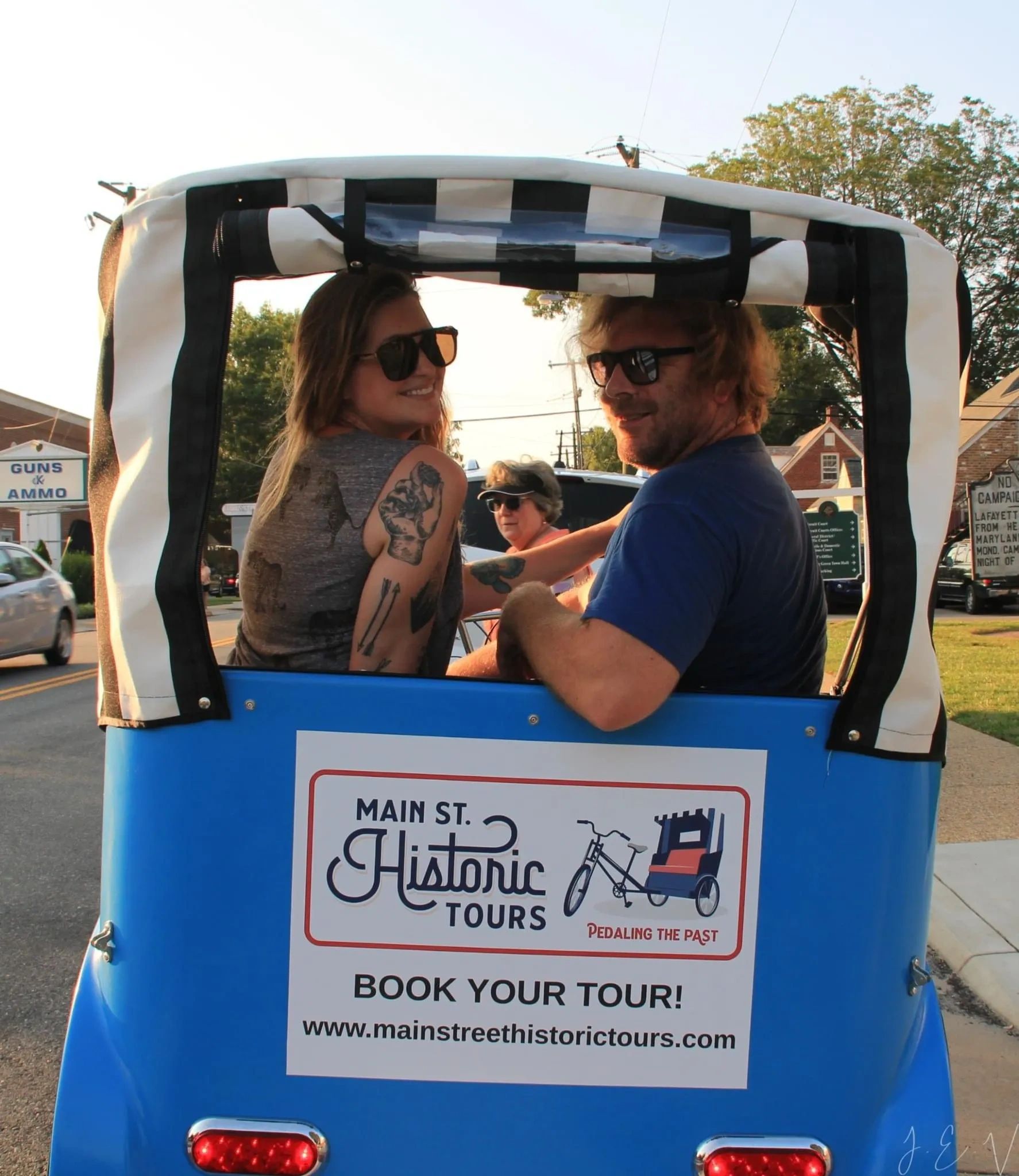 Two people enjoying a historic tour in a pedicab.
