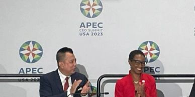 Two APEC participants applauding at the CEO Summit.