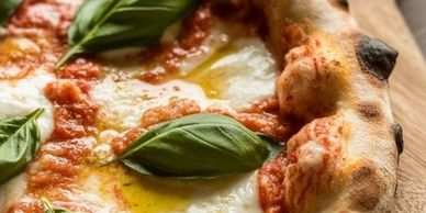 Close-up of a Margherita pizza with fresh basil leaves and melted cheese.