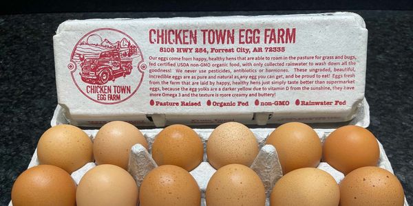 A carton of brown chicken eggs with the Chicken Town Egg Farm branding on it.