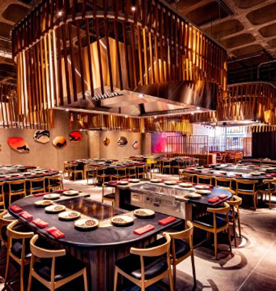 Modern restaurant interior with circular tables and warm lighting.