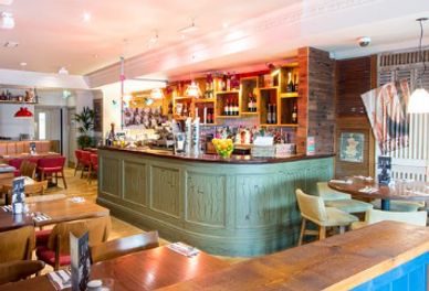 Cozy bar area with wooden furniture and warm lighting.