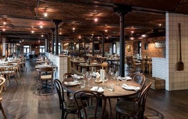 Cozy upscale restaurant with wooden furniture and warm lighting.