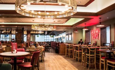 Interior of a modern restaurant with warm lighting and wooden furniture.