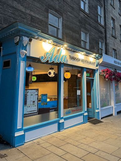 Blue storefront of Ada Turkish Restaurant with illuminated signage.