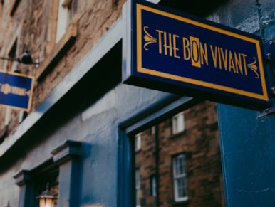 Signboard of 'The Bon Vivant' restaurant on a blue wall.